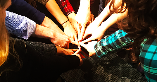 Circle of people with their fingers all touching in the middle and link to article about OSW