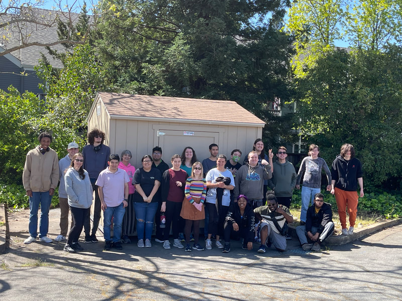ABLED clients posing for a picture outside in front of a TuffShed